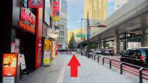 六本木交差点に渋谷側から向かう歩道　左側にハンバーガーショップのウエンディーズ、その先に富士そばがある　右側は車道ですぐに信号