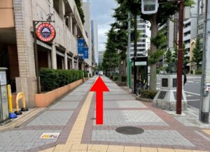 りょうごくえきにしぐちしゅうへんのこくぎかんどおりの写真です 左手にサンマルクカフェの看板と、両国ビューホテルがあります あかいまっすぐの矢印がかかれています